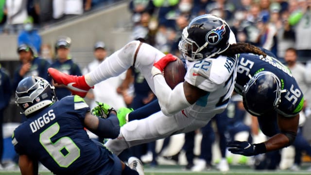 Tennessee Titans running back Derrick Henry (22) is tackled by Seattle Seahawks linebacker Jordyn Brooks (56) and strong safety Quandre Diggs (6) after making a reception during the fourth quarter at Lumen Field.